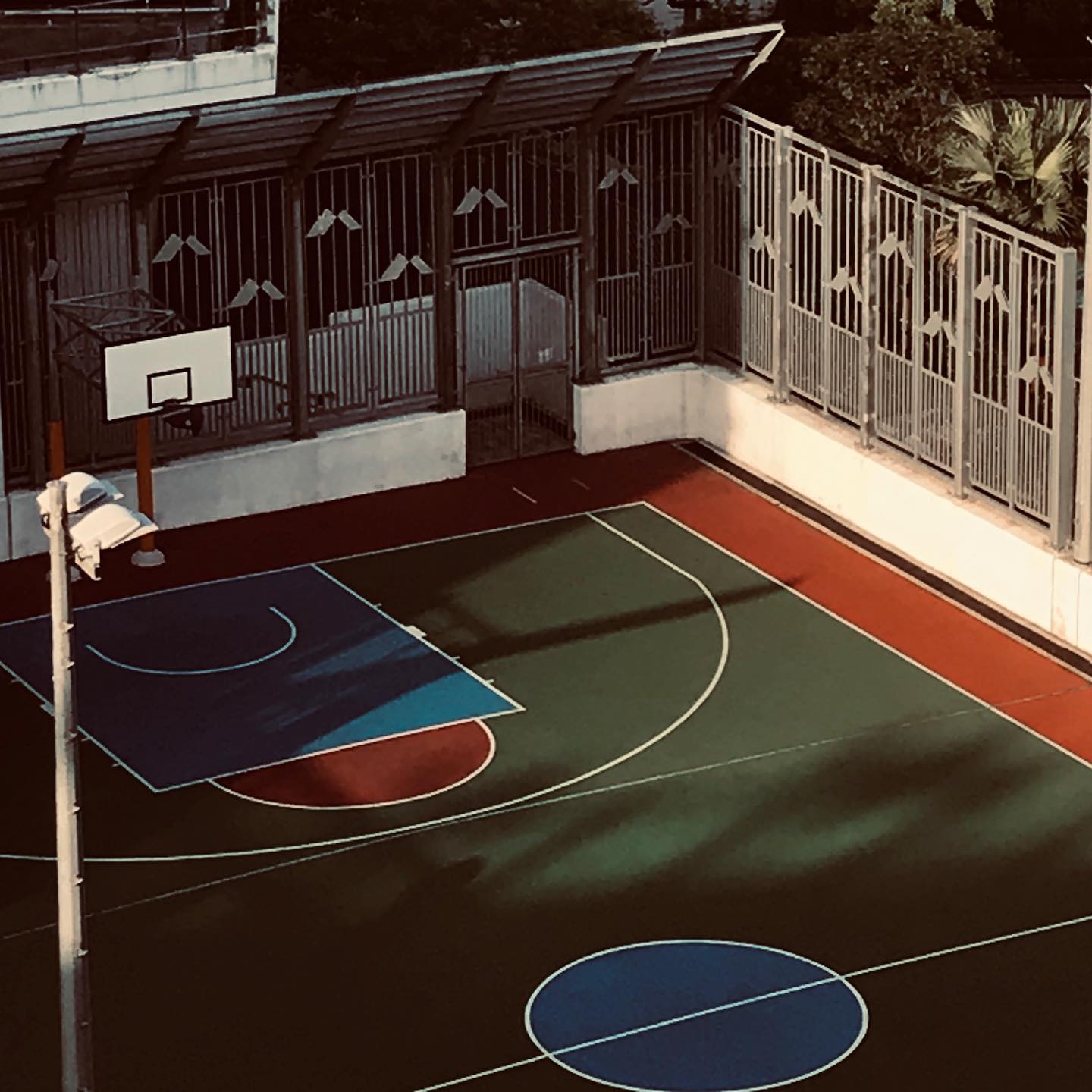 A multicolor basketball court seen from above inside an old building.